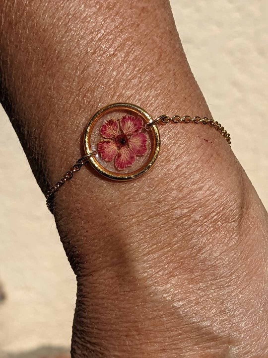 Bracelet contenant une véritable fleur séchée fuschia