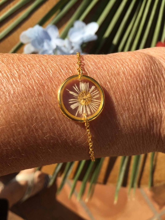 Bracelet doré en résine contenant une véritable fleur séchée blanche