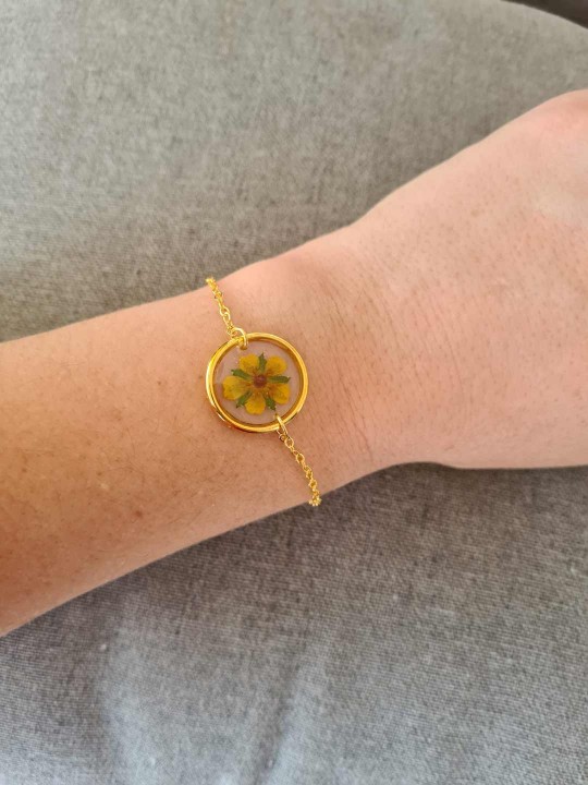 Bracelet doré en résine contenant une véritable fleur séchée jaune