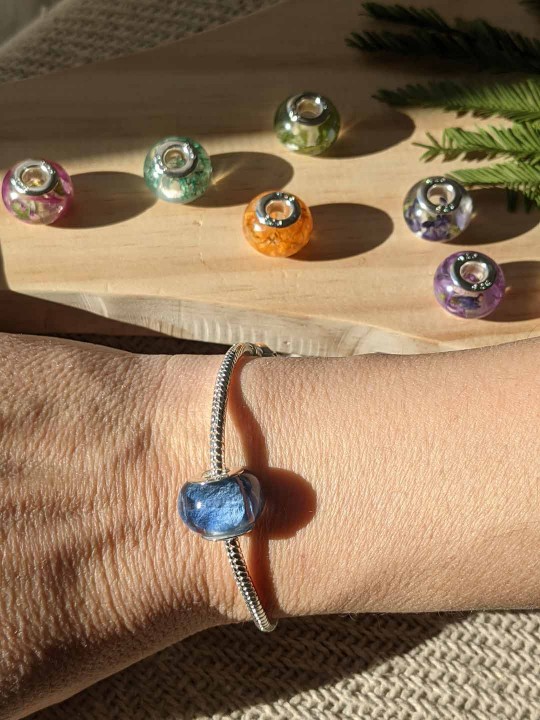 Bracelet avec charm perle en résine contenant de véritables pétales d'hortensia bleu