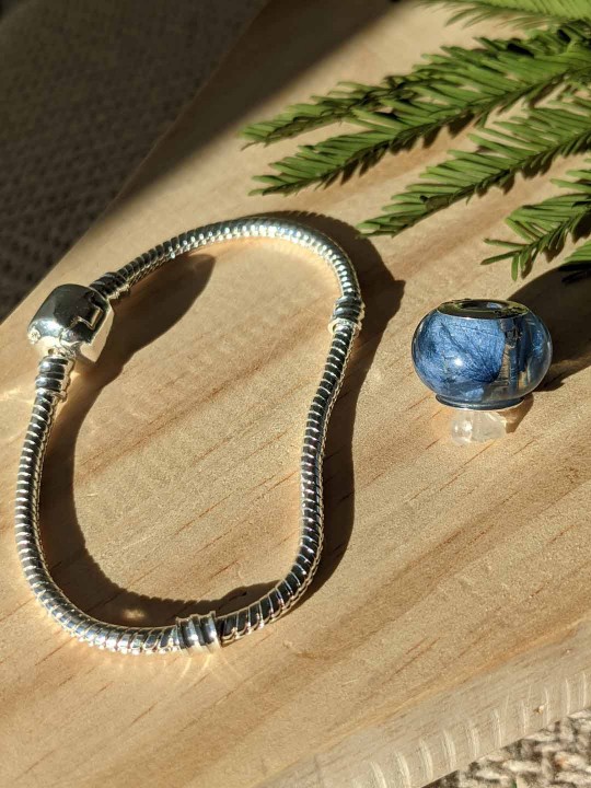 Bracelet avec charm perle en résine contenant de véritables pétales d'hortensia bleu
