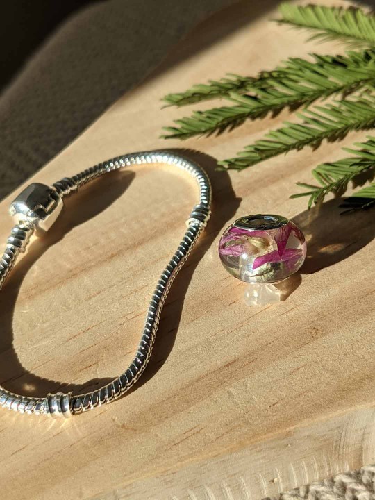 Bracelet avec charm perle en résine contenant de véritables fleurs fushia