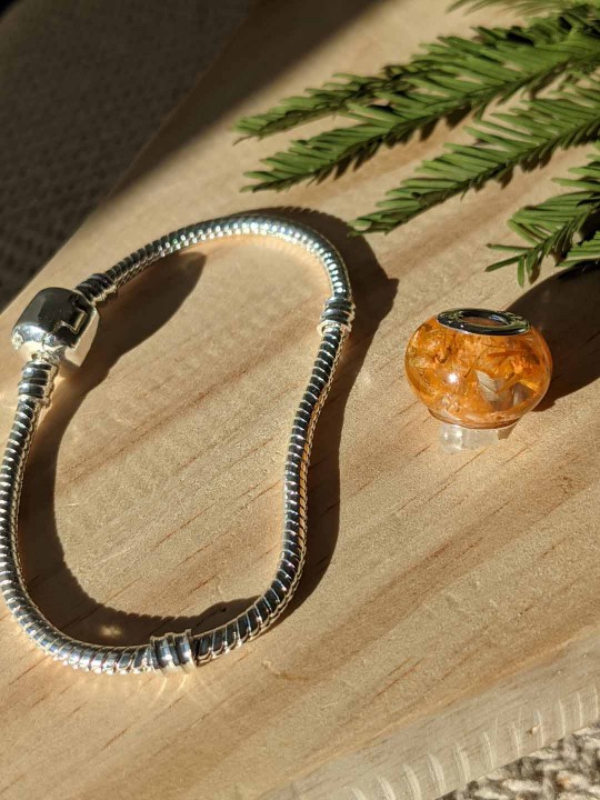 Bracelet avec charm perle en résine contenant de véritables fleurs orange