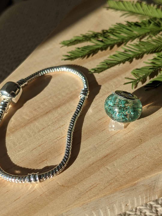 Bracelet avec charm perle en résine contenant de véritables fleurs turquoise
