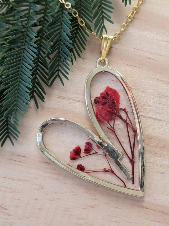 Collier coeur en résine contenant de véritables fleurs rouges