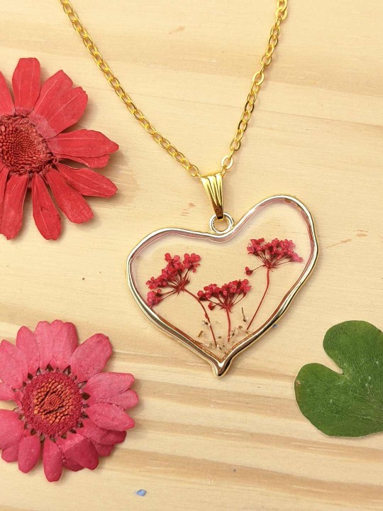 Collier coeur en résine contenant de véritables fleurs rouges