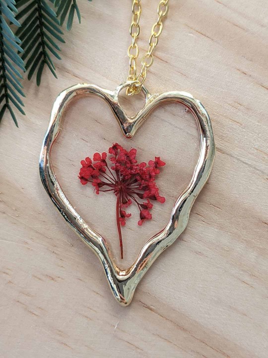 Collier coeur en résine contenant de véritables fleurs rouges