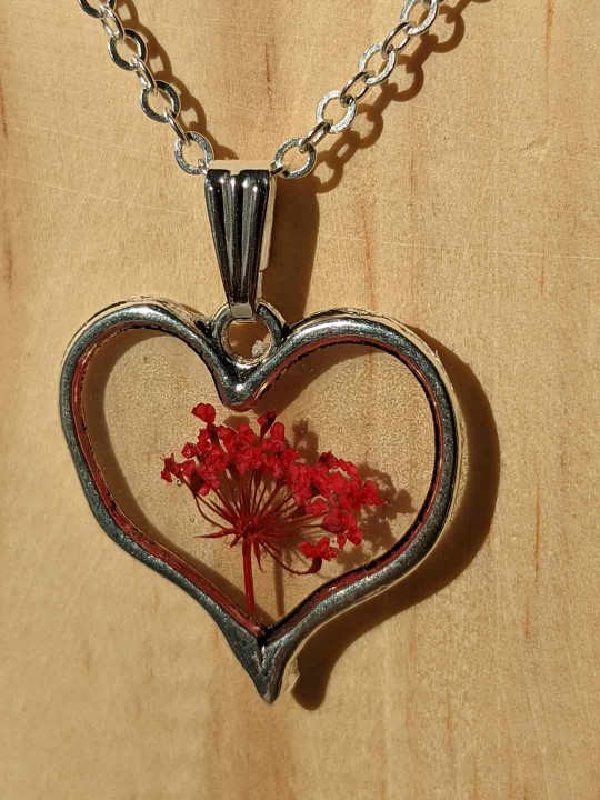 Collier coeur en résine contenant de véritables fleurs rouges