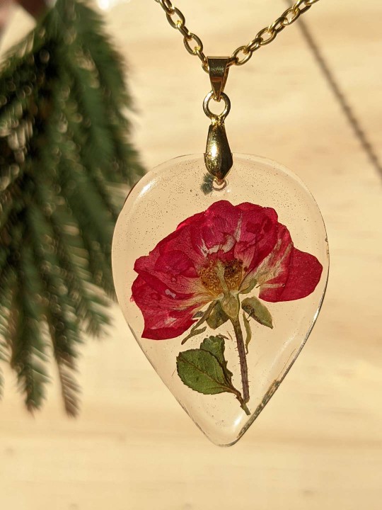 Collier goutte transparente en résine contenant une véritable rose