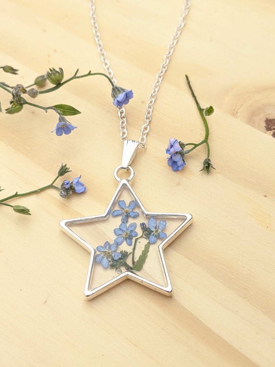 Collier étoile en résine contenant de véritables fleurs de Myosotis