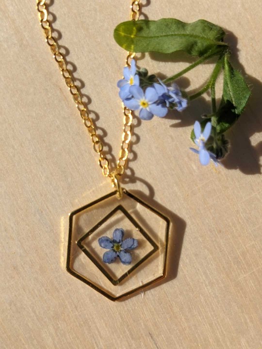 Collier hexagonal en résine contenant une véritable fleur de Myosotis