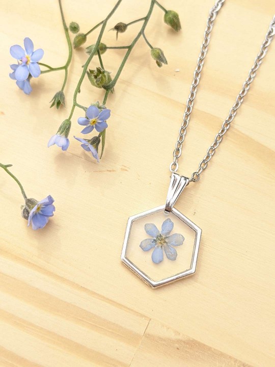 Collier hexagonal en résine contenant une véritable fleur de Myosotis