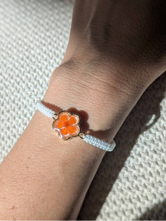 Bracelet contenant une véritable fleur orange